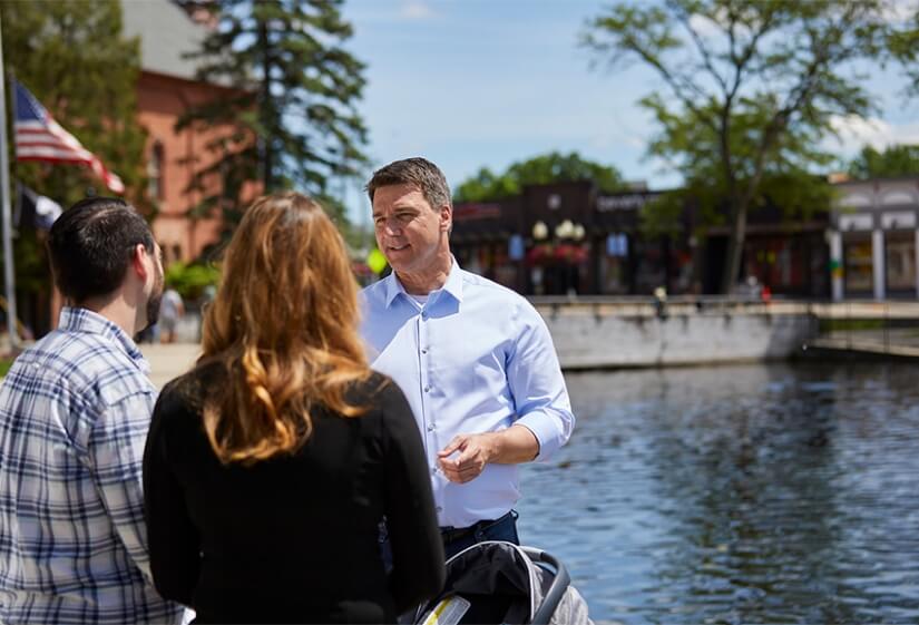 Paul Junge speaking with voters by a pond