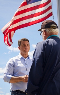 Paul Junge speaking with a veteran by the flag